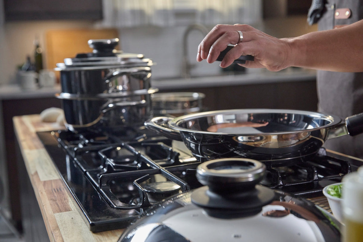 A by AMC active cookware on a home stovetop with the Visiotherm built into the lid knob.