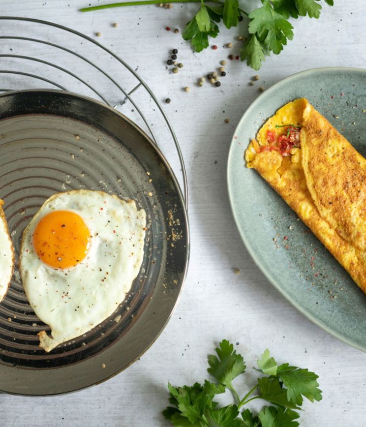 Fried eggs in the oPan next to a folded omelet