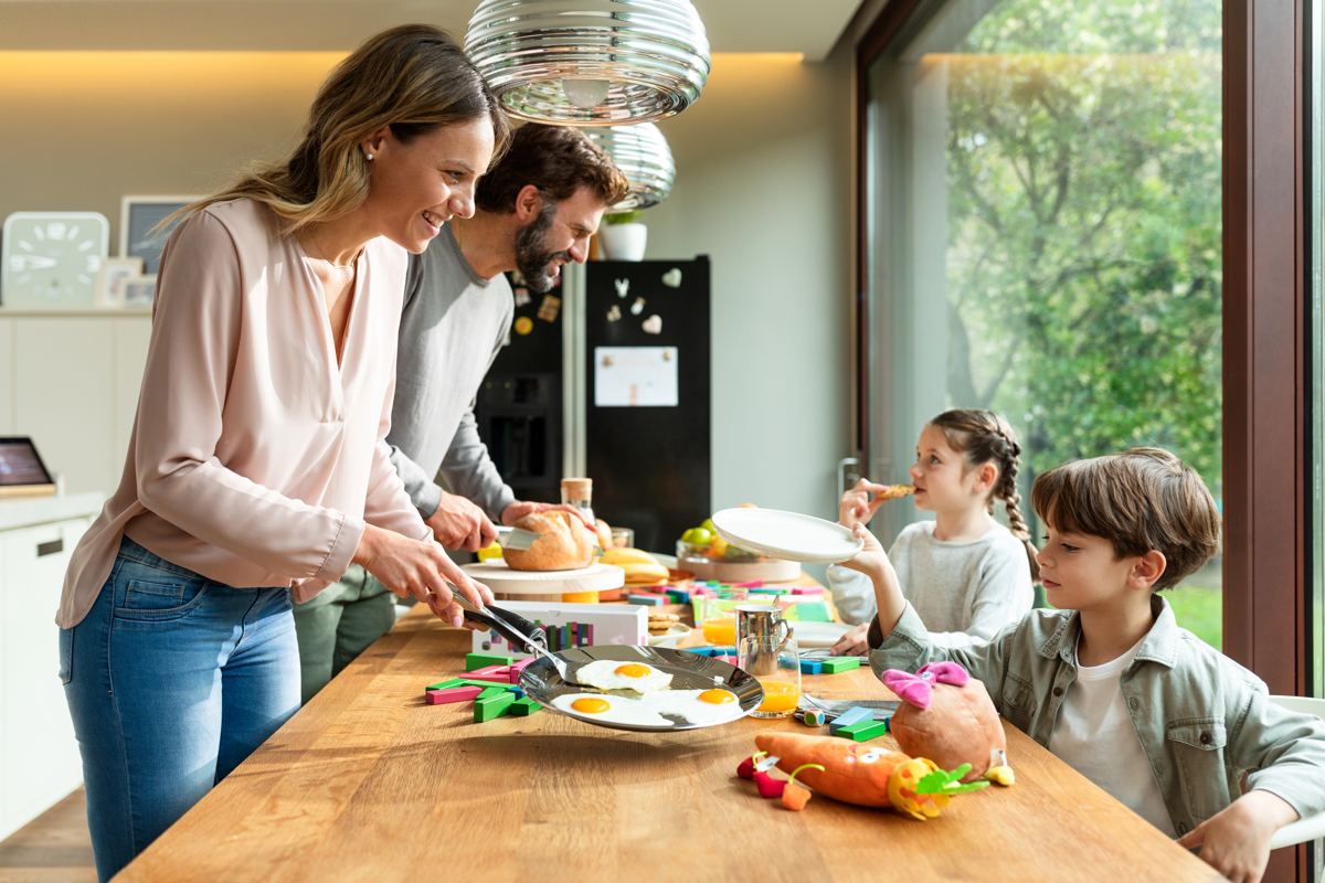 A family making breakfast together at the kitchen island